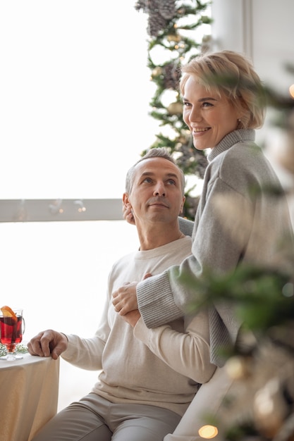 adult man and woman hugging sitting near a round festive table