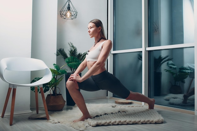 Adult mature woman doing yoga at home living room