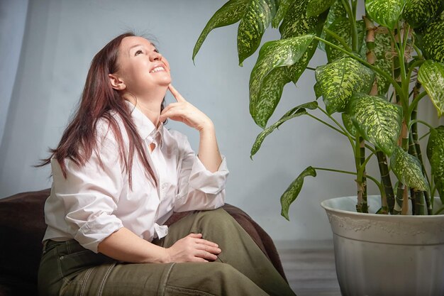 Photo an adult mature woman is relaxing in a cozy room with flowers relax and rest middleaged girls