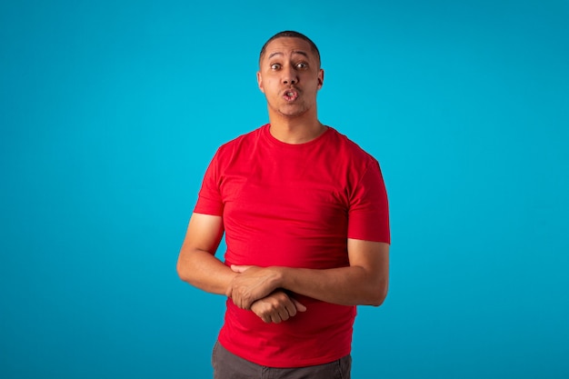 Adult in red shirt on a blue background, making various facial expressions.