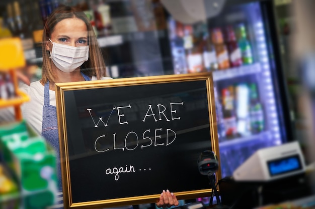 adult shop assistant holding announcement board