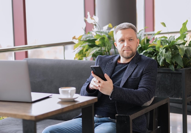 Adult successful man in cafe parting on laptop