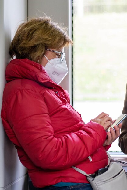 Adult woman dressed in red adapting to new technologies using a smartphone