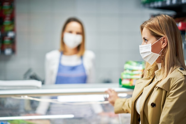 adult woman in medical mask shopping for groceries