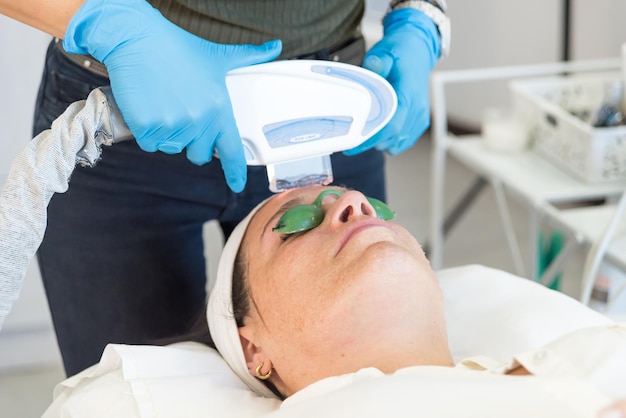 adult woman in a spa center close up removing wrinkles with laser