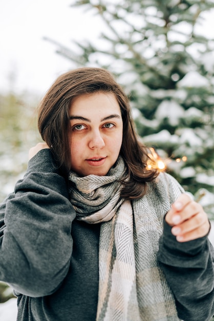 Adult young woman with sparklers on  winter pine forest