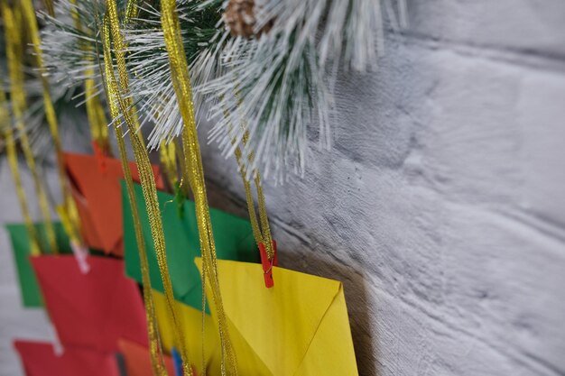 Advent calendar on a background of a brick wall. Multicolored envelopes made by hand.