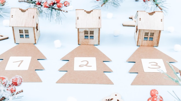 Advent calendar with craft trees numbers and wooden houses on blue