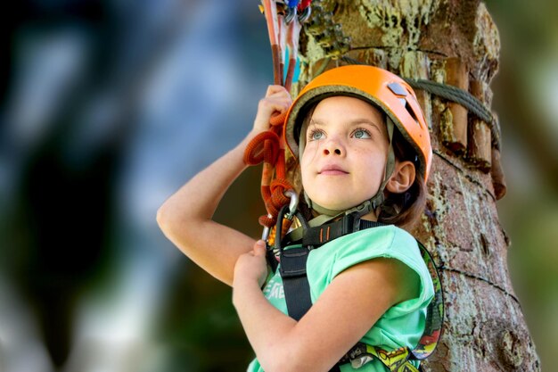 Adventure climbing high wire park - people on course in mountain helmet and safety equipment