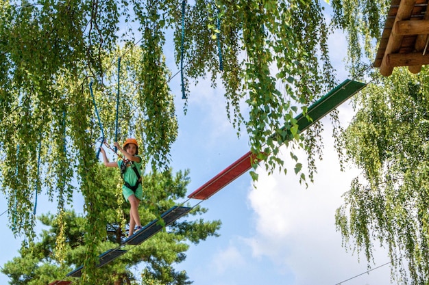 Adventure climbing high wire park people on course in mountain helmet and safety equipment