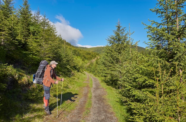 Adventure man hiking wilderness mountain with backpack