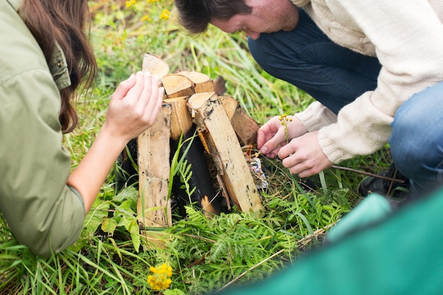 adventure, travel, tourism and people concept - close up of happy friends hikers roasting marshmallow on fire