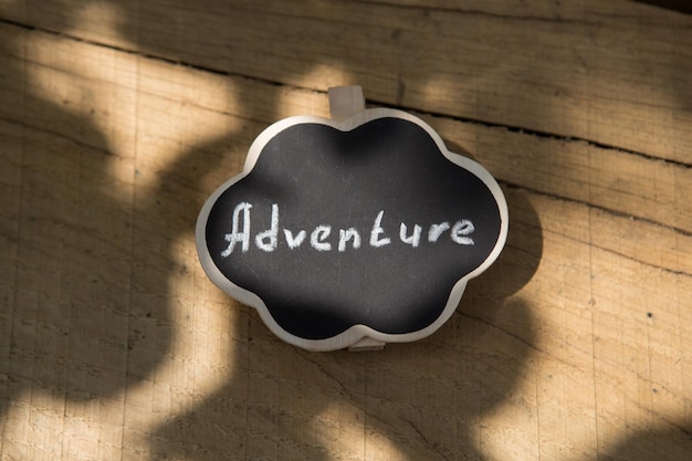 Adventure waiting for you concept small sign with Adventure inscription outdoors wooden background