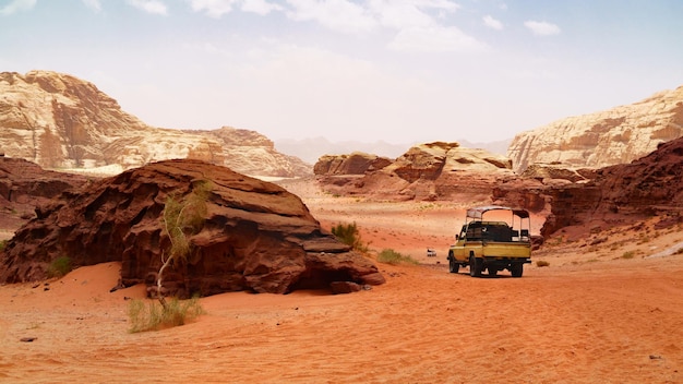 Adventures safari jeep car in Wadi Rum desert Jordan Middle East known as The Valley of the Moon Red sands sky with haze Designation as a UNESCO World Heritage Site