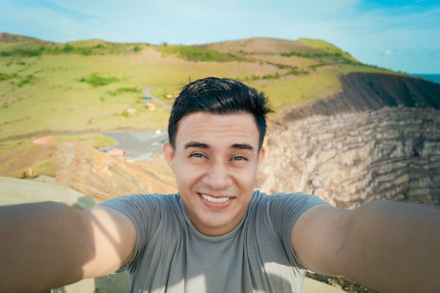 Adventurous man taking a selfie at a viewpoint Close up of person taking an adventure selfie Tourist taking a selfie at a viewpoint Handsome tourist taking a selfie on vacation