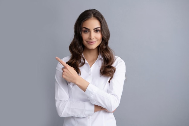 Advertising something by pointing. Career girl point finger grey background. Pointing finger