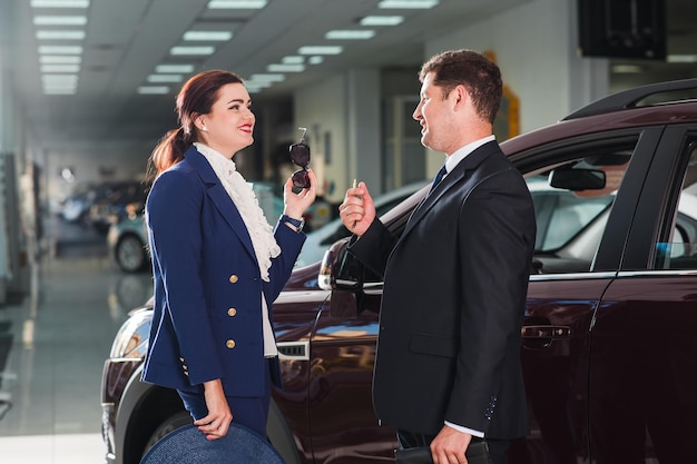 Advice on buying a carYoung business man chooses an expensive SUV at the car dealership