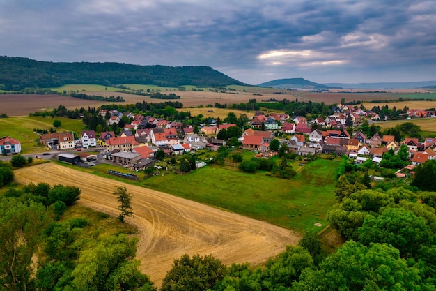 Aer ial view of a german village surrounded by meadows farmland and forest in germany