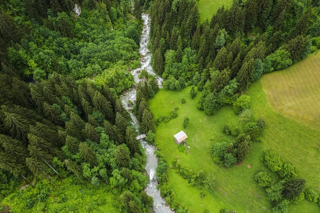 Aerial birds eye view showing epic Krimml waterfalls surrounded by big forest trees in mountains