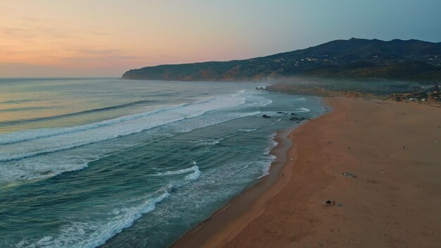 Aerial calm marine evening at beautiful sandy shoreline foamy ocean waves beach