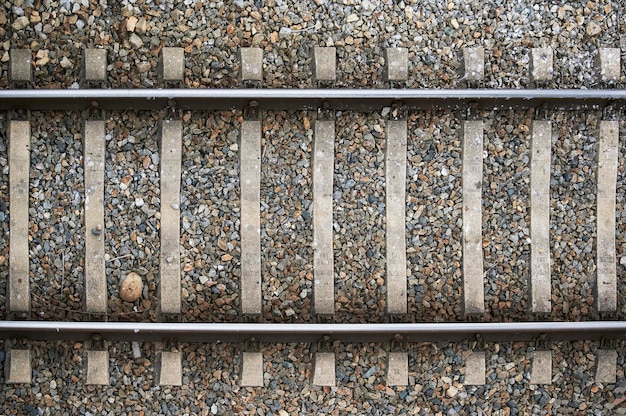 Aerial and detailed view of the train tracks built in metal and with stones around to use as a background