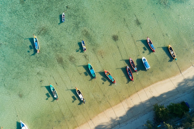 Aerial drone bird's eye view photo Top down of tropical sea with long tail fishing boats Travel boats at phuket thailand Amazing top view sea Beautiful sea surface