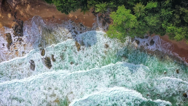 Aerial drone footage of sea ocean waves reaching shoreBeach with aerial drone Beach clear turquoise top view Beautiful beach