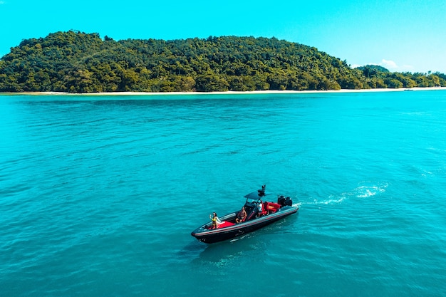 Aerial drone photo of inflatable power boat cruising in high speed in tropical emerald clear water sea