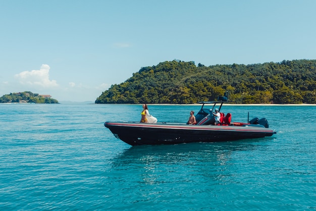 Aerial drone photo of inflatable power boat cruising in high speed in tropical emerald clear water sea