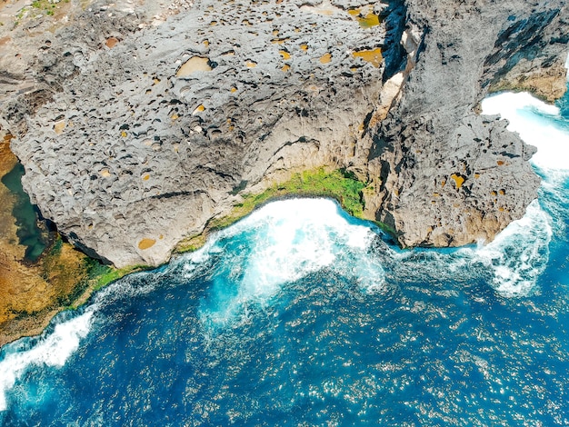 Aerial drone top view of coral beach and blue ocean waves In Nusa Penida Bali Indonesia Overhead View Of Rocky Coast And Coves