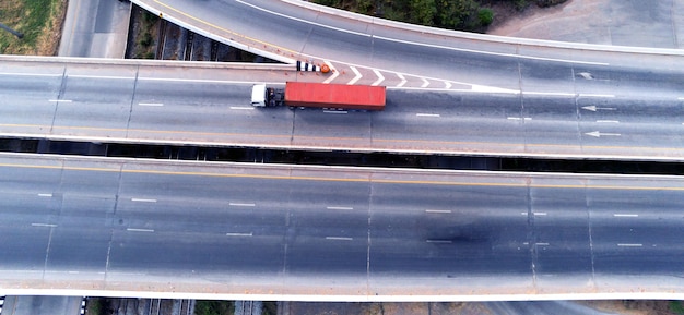 Aerial drone view of cargo white Truck on highway road with green container, transportation concept,import,export logistic industrial Transporting Land transport on the asphalt expressway