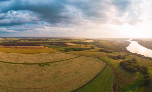 Photo aerial drone view of river and wheat field landscape in sunny summer evening