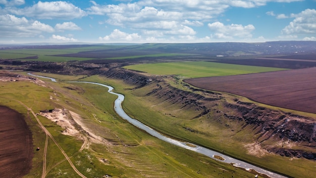 Aerial drone view of a valley with floating river, fields around in Moldova