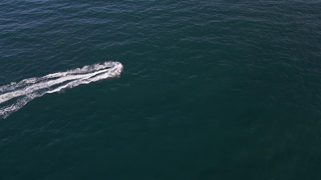 Aerial dynamic view of the water scooter or personal watercraft or ski jet racing through the sea waves