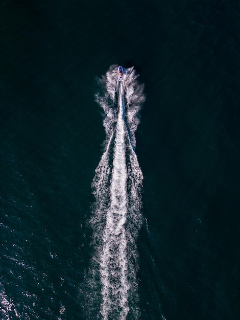 Photo aerial dynamic view of the water scooter or personal watercraft or ski jet racing through the sea waves