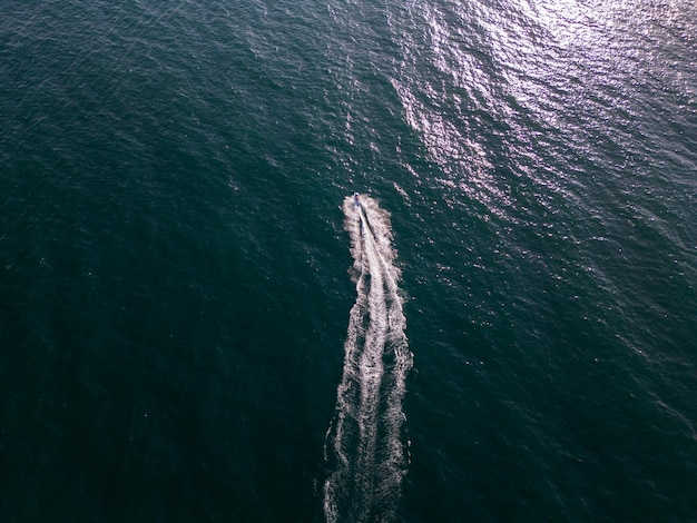 Aerial dynamic view of the water scooter or personal watercraft or ski jet racing through the sea waves