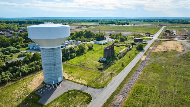 Aerial farmland farm fields white water tower abandoned buildings silos destroyed train tracks