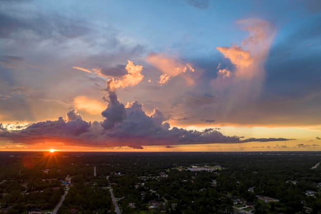 Aerial landscape view of suburban private houses between green palm trees in Florida quiet rural area at sunset