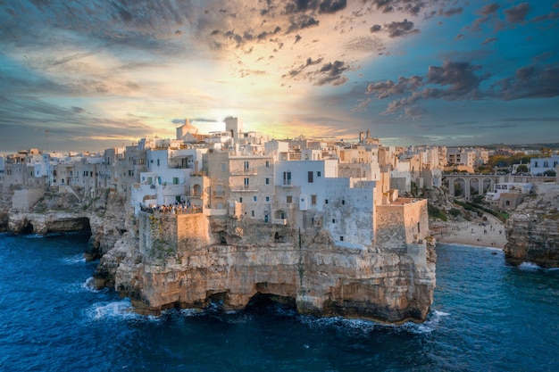 Aerial magnificent view of the Polignano a Mare town gleaming under the sunset in Italy