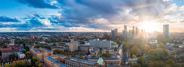 Aerial panorama of the London city financial district with many iconic skyscrapers near river Thames at sunset.