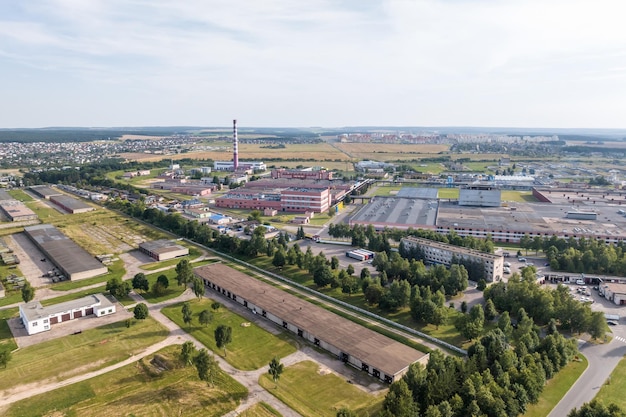 Aerial panoramic view of city with a huge factory with smoking chimneys in the background