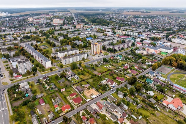 Aerial panoramic view from a great height of a small provincial green town with a private sector and highrise apartment buildings