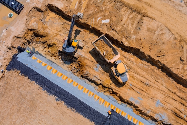 Aerial panoramic view of sewerge construction trench for laying external sewage drainage system construction at earthworks