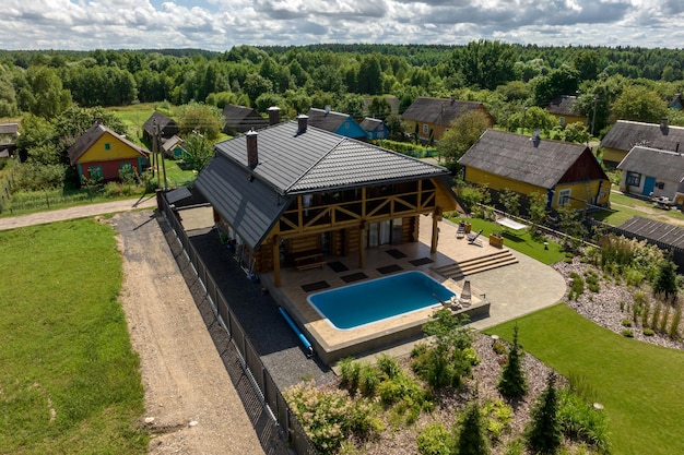 Aerial panoramic view on wooden eco house or homestead with pool in green village