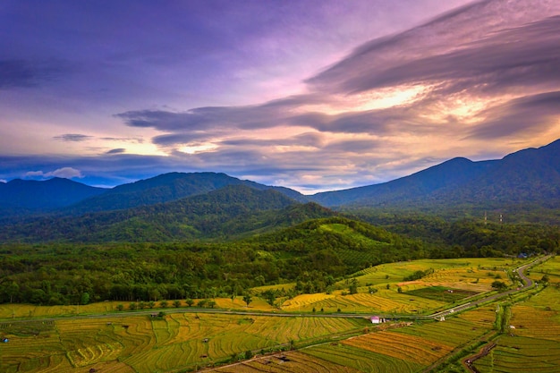 Aerial photo of natural panorama of Indonesia morning view in rice fields and mountains