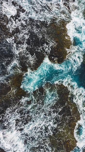 Aerial photography of waves crashing on rocks