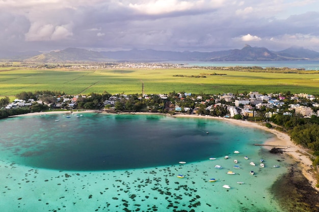 Aerial picture of the east coast of Mauritius Island. Beautiful lagoon of Mauritius Island shot from above. Boat sailing in turquoise lagoon.