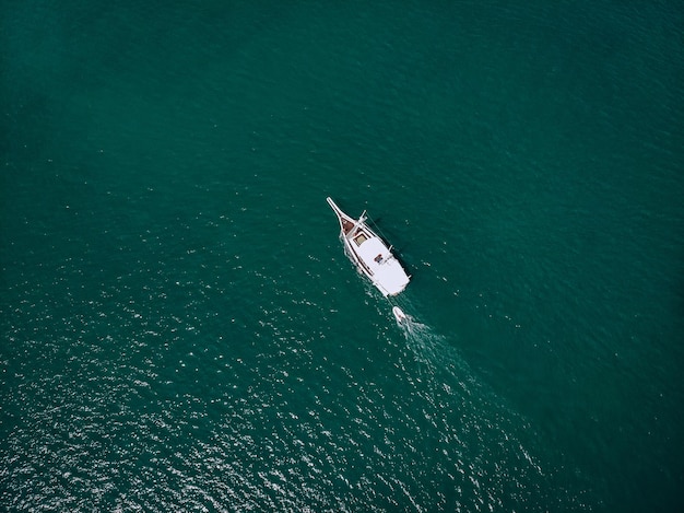 Aerial picture of an isolated yacht with brown wooden design in the sea