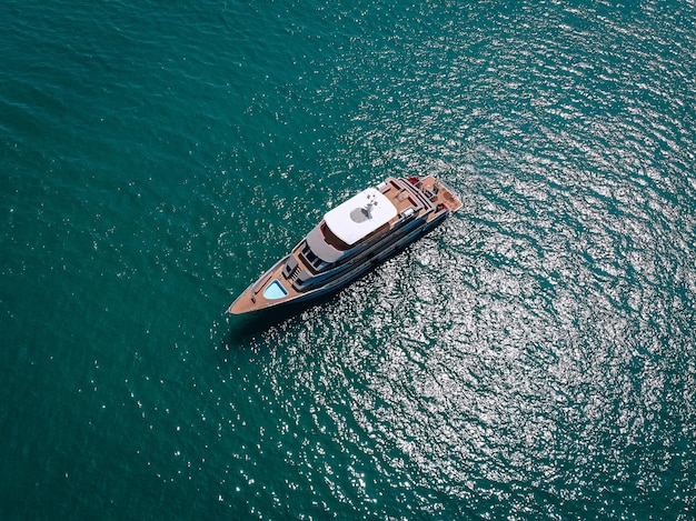 Aerial picture of an isolated yacht with brown wooden design in the sea