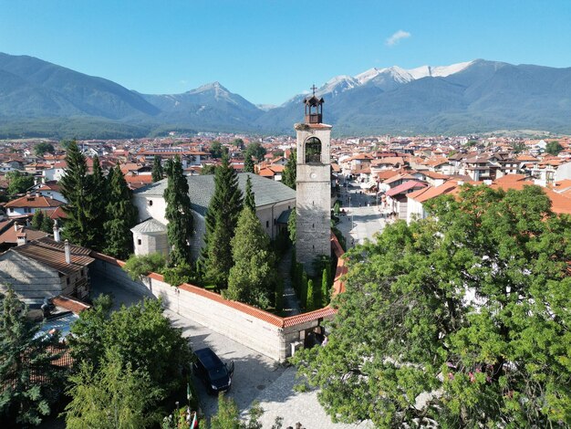 Aerial shot of Holy Trinity Church around houses and green trees in Bansko Bulgaria